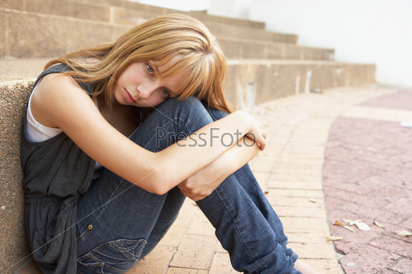 Unhappy Female Teenage Student Sitting Outside On College Steps