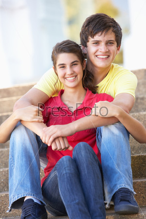 Teenage Couple Sitting On College Steps Outside