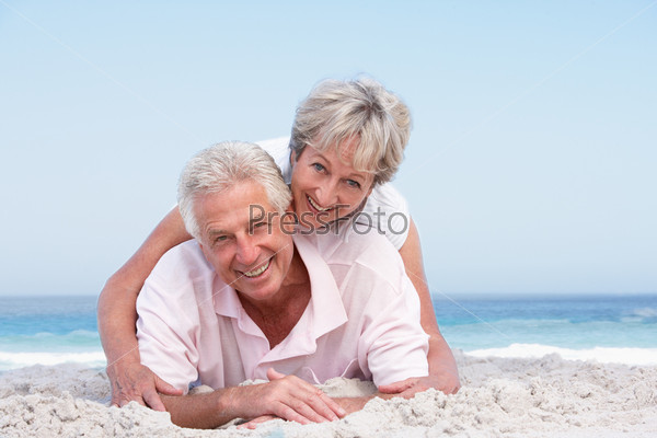 Senior Couple Relaxing On Beach Holiday