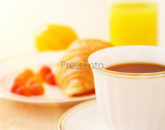 Breakfast. A cup of coffee, croissant, orange juice and berries