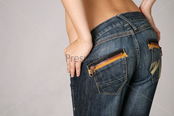 Sexy young woman trying on a pair of blue jeans in the dressing room