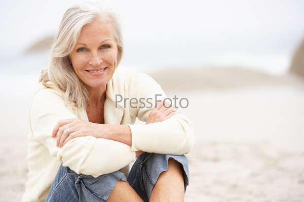 Пожилая женщина отдыхает на пляже