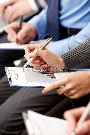 Close-up of human hands with pens over business documents, stock photo