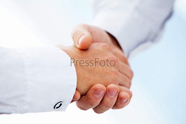 Photo of handshake of business partners after signing promising contract