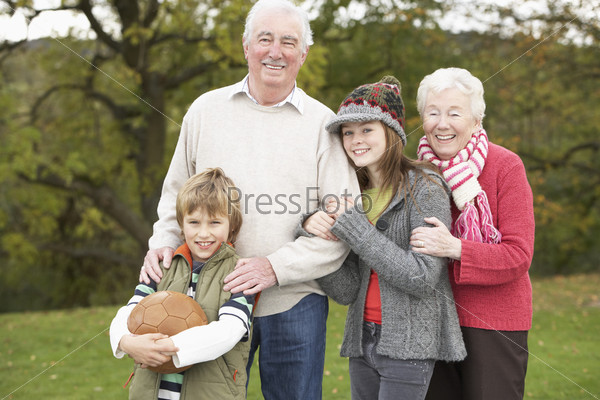 Grandparents With Grandchildren Holding Football Outside