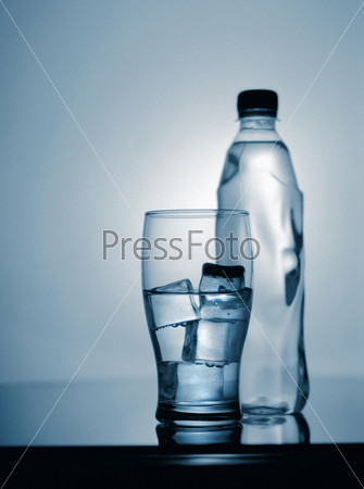 glass of cold mineral water with ice and plastic bottle. scanned from 6x7 film