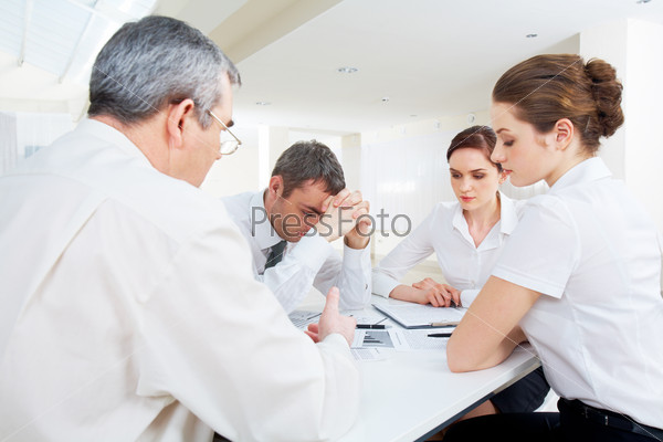 Portrait of business people deciding problems of project at meeting