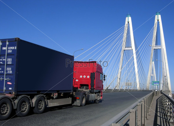 blue-red truck driving on cable-braced bridge