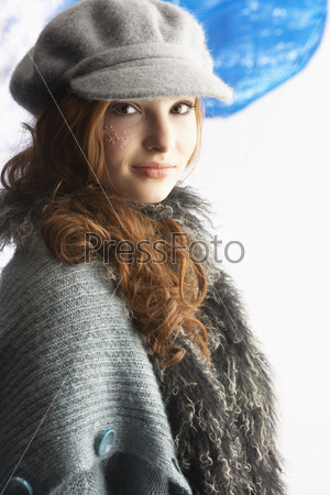 Модная девушка в кепке и трикотажной одежде, студийный портрет