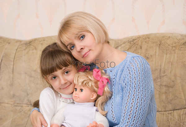 Portrait of mum and daughter with a doll