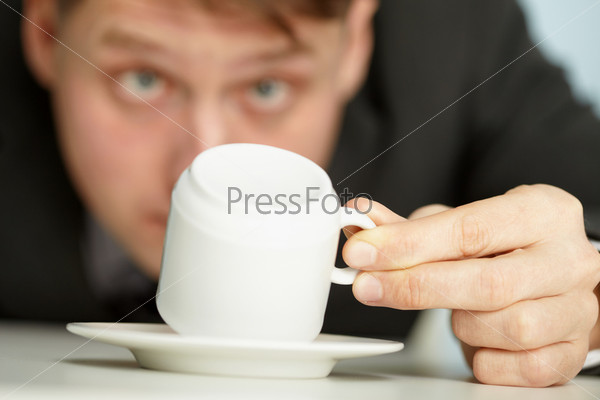 Young businessman makes predictions using coffee grounds - close up, stock photo