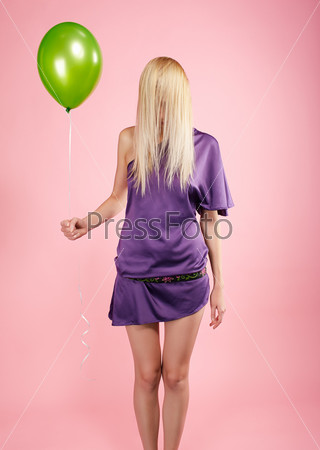 portrait of beautiful blonde party girl with balloon on pink. face hiden in hair