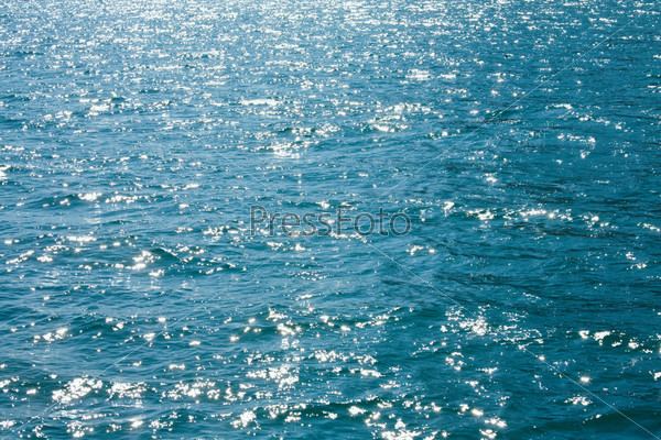 Azure sea water surface with ripple and sun reflection sparkles, stock photo