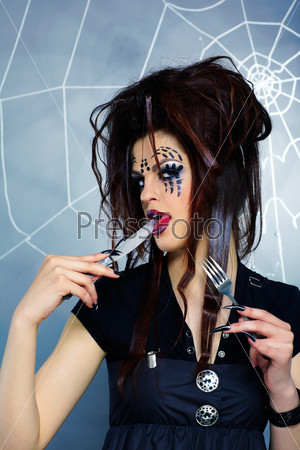 portrait of girl with spider bodyart of face zone with knife and fork