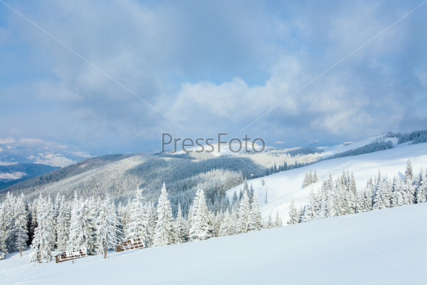winter calm mountain landscape with sheds and mount ridge behind (Kukol Mount, Carpathian Mountains, Ukraine)