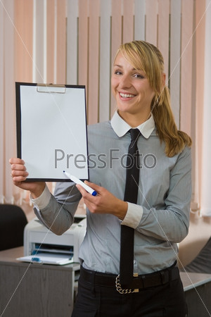 The businesswoman at office shows clipboard in hand