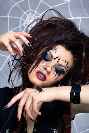 portrait of girl with spider bodyart of face zone with real spider Brachypelma smithi on her hand