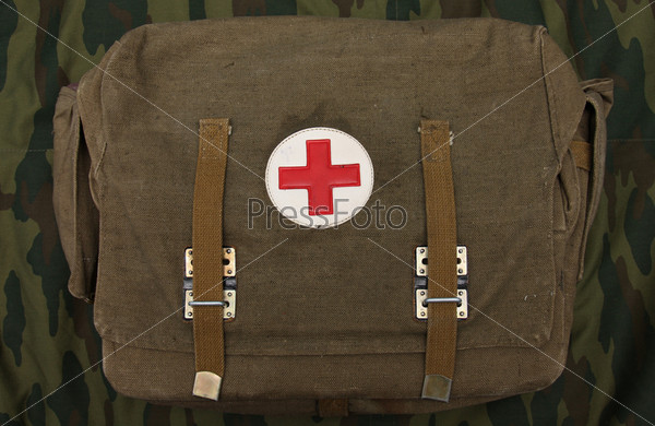 Сумка военного медика на фоне ткани защитного цвета