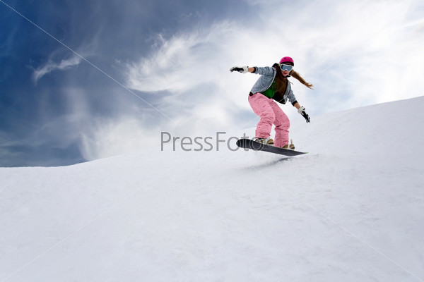 Девочка катается на сноуборде в горах