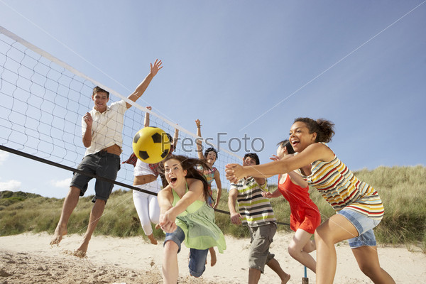 Group Of Teenage Friends Playing Volleyball On Beach