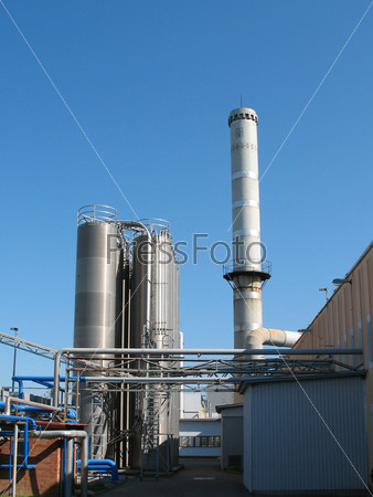 The factory chimney photographed on a background of the blue sky