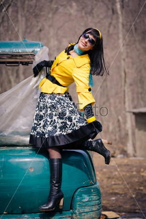 glamorous young woman posing on a ski holiday base, in early spring when the snow began to turn into a mud