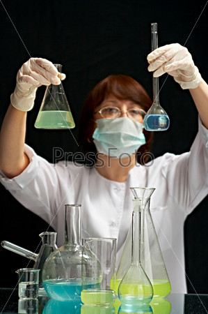 woman-laboratory assistant in chemical laboratory on black background