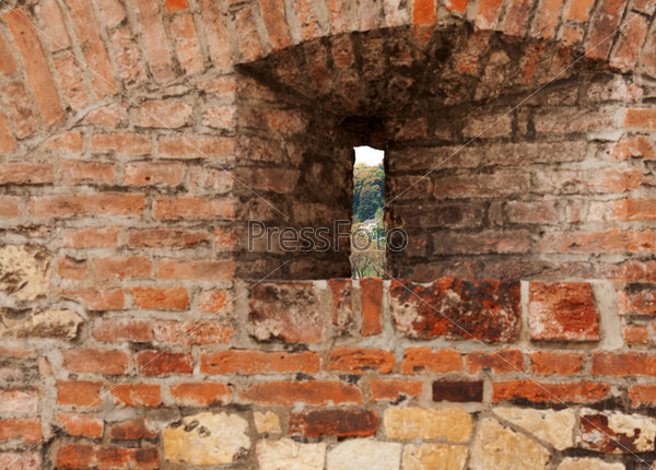 Loop-hole in the brick wall overlooking the forest, stock photo