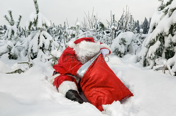 Santa Claus sitting looking for presents in his sack in the forest