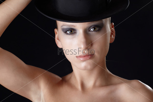 portrait of beautiful dark haired slavonic model posing with black hat