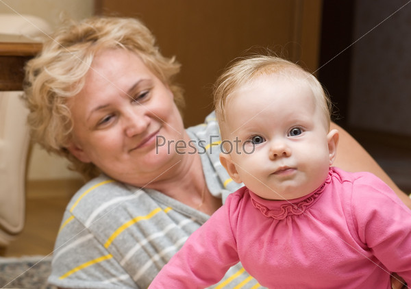 Улыбающаяся бабушка с внучкой на руках