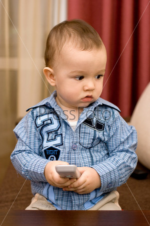 Маленький мальчик в синей рубашке с пультом