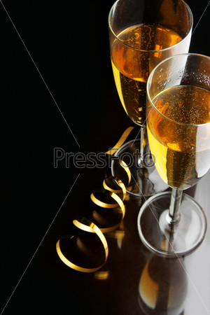 Couple glasses of champagne with gold streamer and space for your own text on left