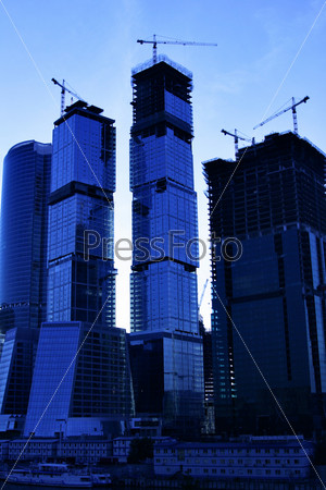 Modern skyscrapers under construction close-up in morning light, stock photo