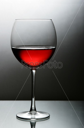 Glass of red wine close-up over black and white background