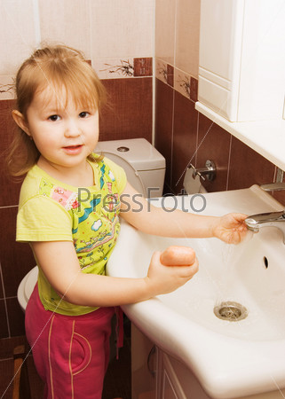 The little girl washes hands