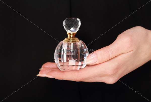 Woman holding vintage perfume bottle in her hand