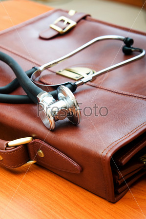 Doctor\'s case with stethoscope against wooden background