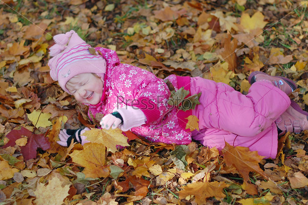 Little girl walks in autumn park