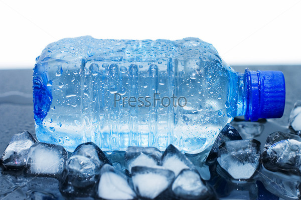 cold mineral water bottle with ice cubes