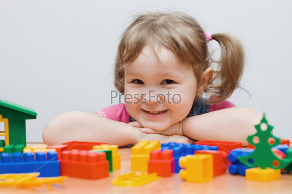 Девочка играет с пластмассовыми блоками
