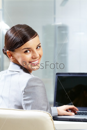 Rear view of young businesswoman doing computer work in office, stock photo