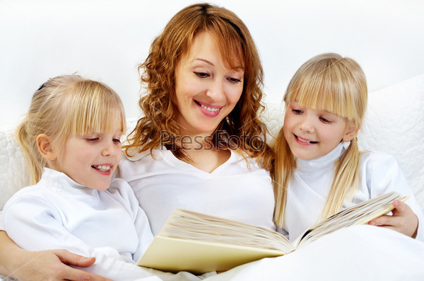 Portrait of mother reading the books to their daughters