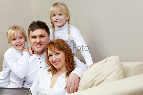 Portrait of cheerful family sitting on the sofa in the room