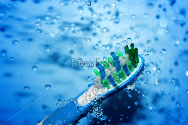 water splashing over toothbrush