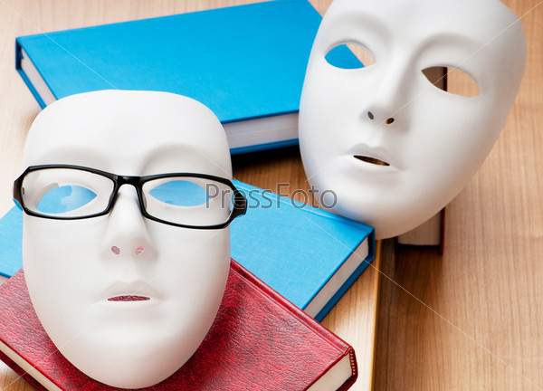 Белые маски, очки и книги на столе