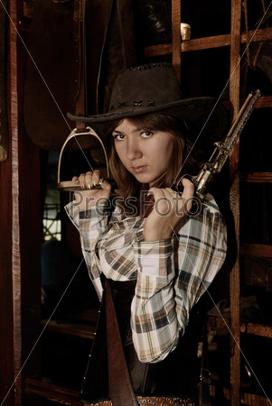 Девушка с пистолетом в одежде стиля "вестерн"