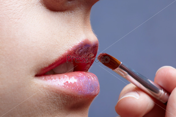 close up portrait of european girl\'s lips make up in process