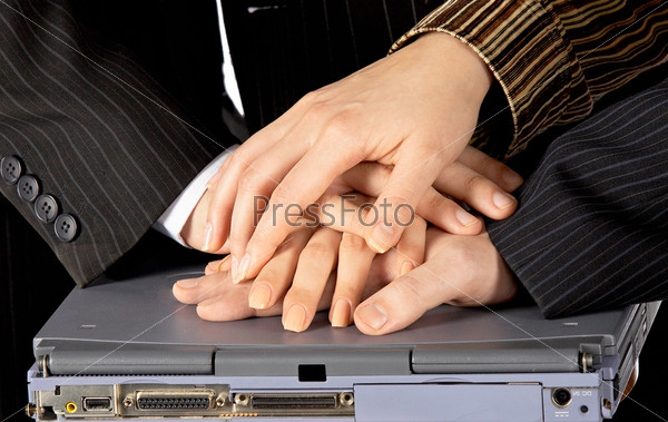 a number of people put their hands on laptop