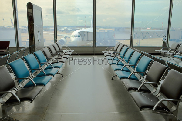 Empty armchairs at the airport and plane